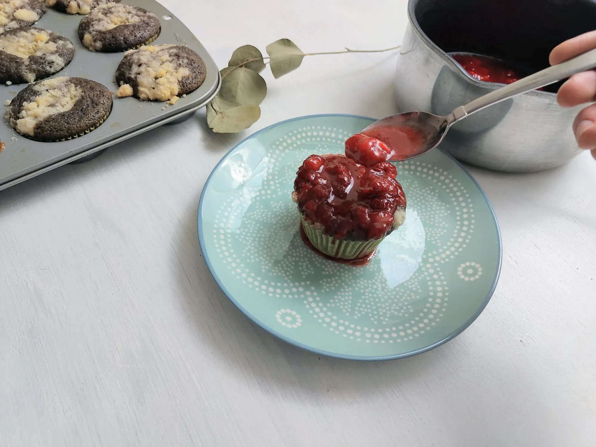 A strawberry muffin topped with strawberry syrup