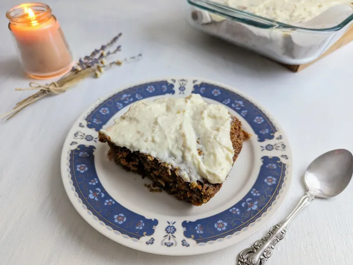 A close up of a carrot cake oatmeal with cream cheese frosting on a plate