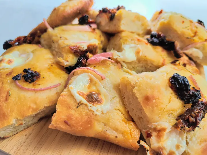 Tomato Mozzarella Focaccia in slices on a cutting board